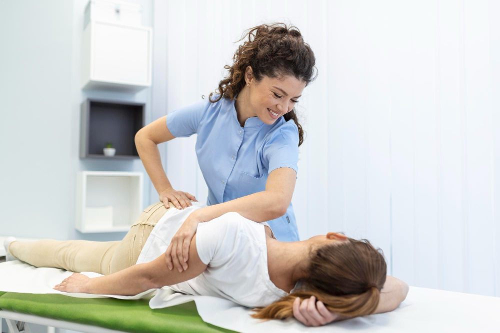young woman doctor chiropractor osteopath fixing lying womans back with hands movements during visit manual therapy clinic professional chiropractor during work